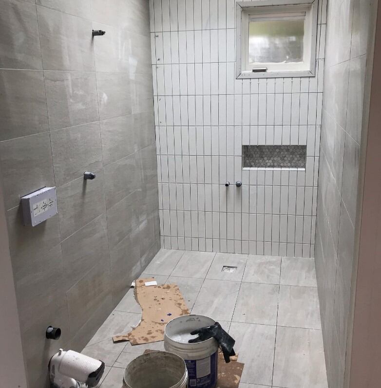 Mid-stage bathroom renovation featuring modern fixtures and light grey subway tiles.