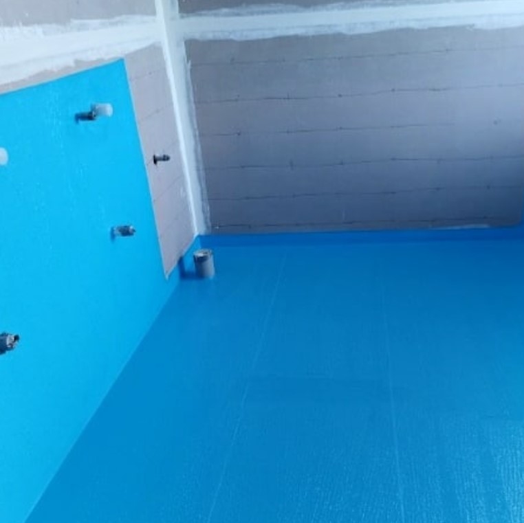 Blue-painted floor in a room under renovation, featuring exposed fixtures and unfinished ceiling.