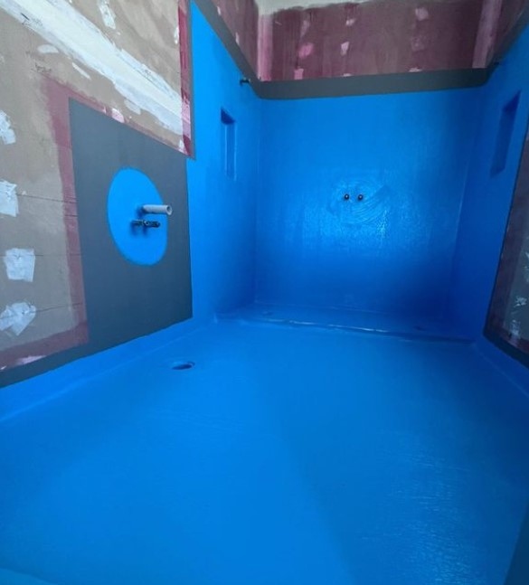 Interior space under renovation with vivid blue walls and contrasting red details in adjacent room.