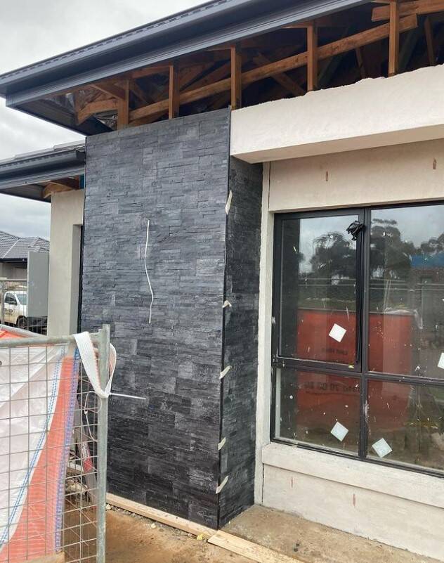 Corner view of building site showing tiled wall and unfinished structures.