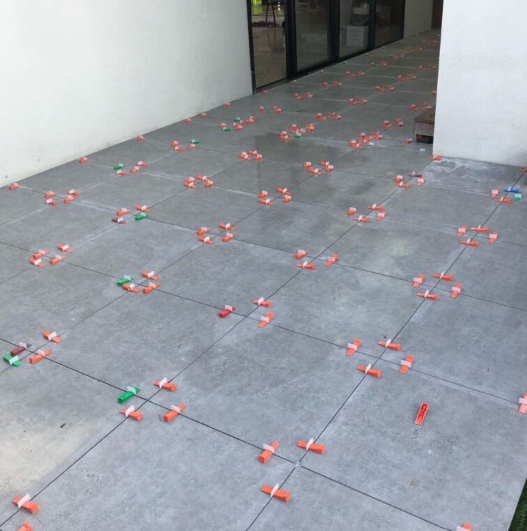 Colourful spoons and fruits scattered across a sunny patio, suggesting a lively outdoor event aftermath.